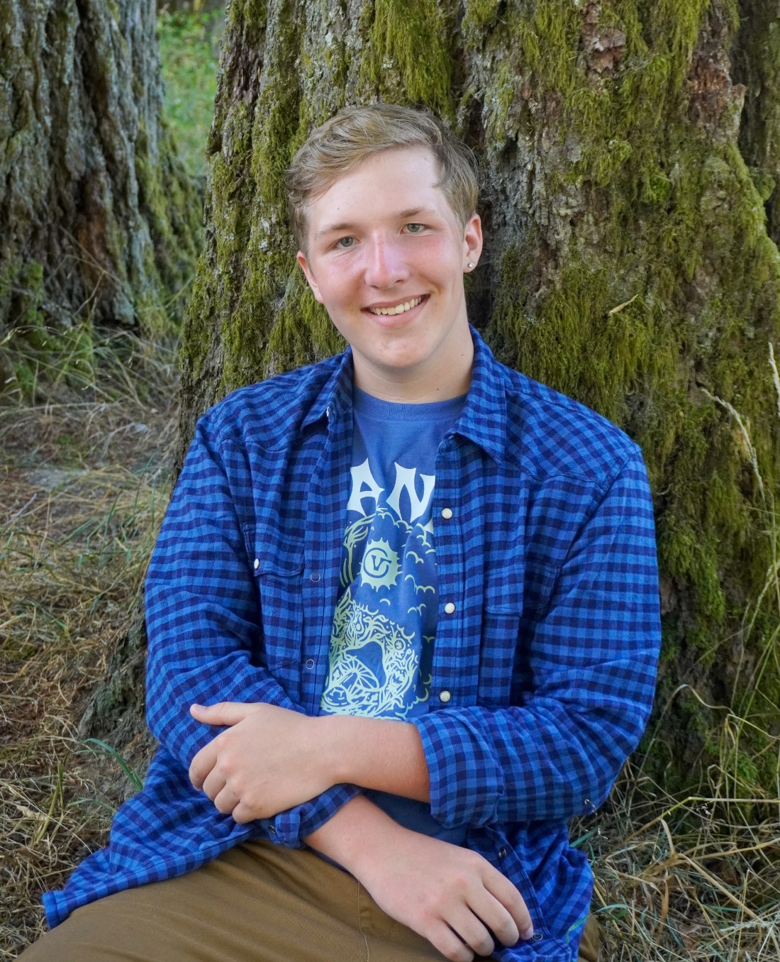 Carter outdoors against a mossy Pacific-Northwest tree